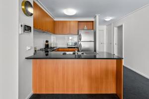 墨尔本独家住宿 - 萨米特公寓的厨房配有水槽和冰箱