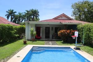 坦波Pura Vida Villa! Beachfront Golf and Country Club Los Delfines 24 hours security的一座带篮球架的房子前的游泳池