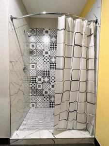 舒格兰The Residency Suites的浴室铺有白色瓷砖,设有淋浴。