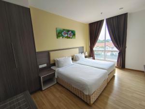 马六甲Hotel MetraSquare的一间卧室设有一张床和一个大窗户