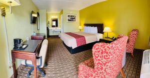 PrincetonAmerican Inn Princeton的酒店客房,配有一张床、一张桌子和椅子