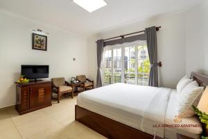 胡志明市LILA Hotel & Apartments的一间卧室设有一张床、一台电视和一个窗口。