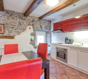 DutovljeCountryside Child Friendly Homes Dutovlje - Happy Rentals的一间厨房,内设红色椅子和桌子