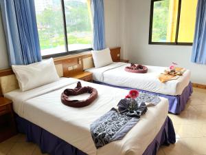 芭东海滩拉迈宾馆的一间设有两张床铺和毛巾的房间