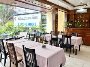 芭东海滩拉迈宾馆的餐厅设有桌椅和大窗户。