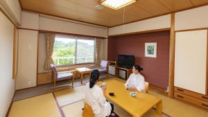 ShōbaraKyukamura Taishakukyo的两位女士坐在带电视的房间里