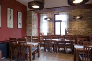 布尔迪山下慕尼雪克Penzion Marjána的餐厅设有木桌和椅子,拥有砖墙