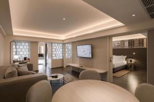 曼谷YANH Ratchawat Hotel的大型客厅设有床铺和电视。