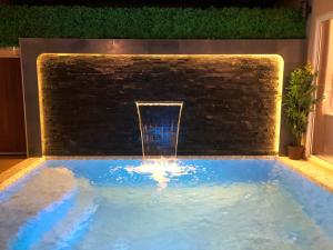 甲米镇The Apex private pool villa Krabi的一座带砖墙的游泳池中的喷泉