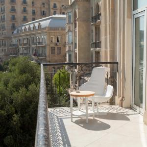 巴库Promenade Hotel Baku的大楼内的阳台配有桌子和两把椅子