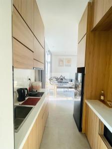 Gò CôngDori House的厨房配有木制橱柜和黑色冰箱。