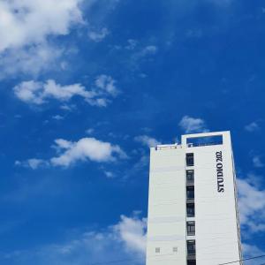 釜山Busan Studio 202的一座高大的白色建筑,背后是蓝天