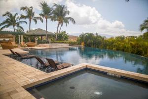 哈普那海滩MAUNA KEA INDULGENCE Indulgent 3BR Waiulaula Home with Stunning View的一个带两把椅子的游泳池,棕榈树