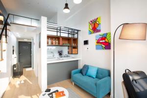 釜山Busan Studio 202的一间带蓝色沙发的客厅和一间厨房