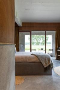 布鲁日BBruT的一间卧室设有一张大床和一个大窗户