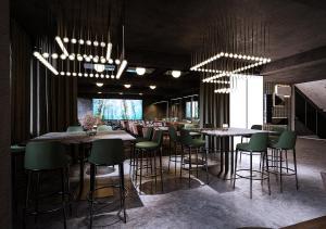 卑尔根Magic Hotel & Apartments Kløverhuset的餐厅内带绿色桌椅的酒吧