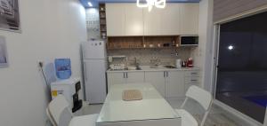 安曼Santorini Breeze Chalet的厨房配有白色桌子和白色冰箱。