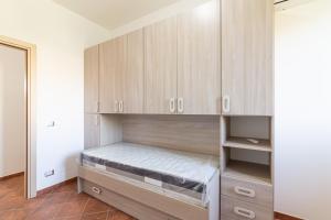库斯托纳奇Appartamento Custonaci Uno的一间卧室配有木制橱柜和一张床