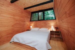 拉戈代希Eco Village In The Forest的卧室配有一张白色的木墙床