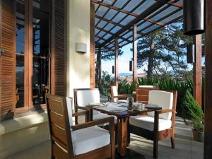 大叻Ana Mandara Villas Dalat Resort & Spa的美景门廊上的餐桌和椅子