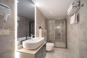 伊斯坦布尔Gatto Suites&Residence的白色的浴室设有水槽和淋浴。