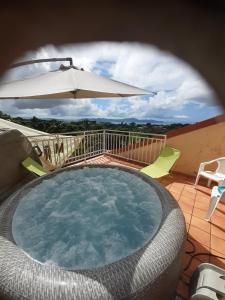 法兰西堡JOYAUX DE TIVOLI VILLA的一个带遮阳伞和桌椅的游泳池