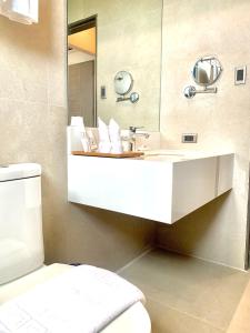 巴科洛德The Henry Hotel Roost Bacolod的浴室设有白色水槽和镜子