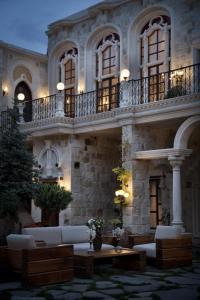 于尔居普萨科里德之家酒店的一座大型石头建筑,在庭院里配有沙发