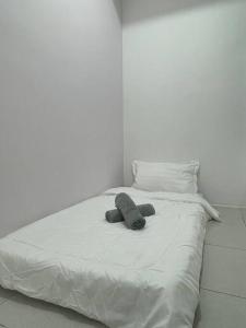 吉隆坡Menjalara Msuite的一张白色的床,上面有一只动物塞满了东西