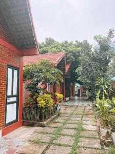 宁平Chu Thuong Bungalow的红砖建筑,庭院里种有植物