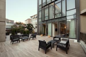 伊斯坦布尔Gatto Suites&Residence的坐在大楼前天井上的一群长椅