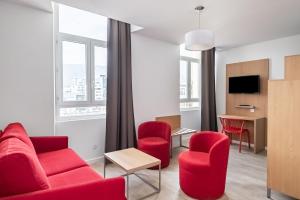 格勒诺布尔家乐中心公寓式酒店的客厅配有红色家具和窗户。
