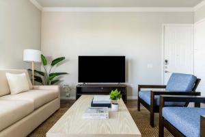 普弗拉热维尔Bright and Spacious Apartments with Gym and Pool Access at Century Stone Hill North in Pflugerville, Austin的带沙发和电视的客厅