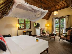 大叻Ana Mandara Villas Dalat Resort & Spa的一间带大床的卧室和一间客厅