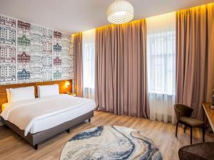 里加里加市中心美居酒店的卧室设有一张白色大床和一扇窗户。