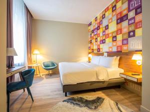 里加里加市中心美居酒店的酒店客房带一张床和一堵广场墙