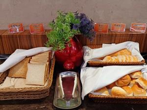 高雄夏优旅居-驳二馆的一张桌子,上面有三篮面包和花瓶