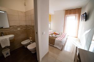 帕尔盖利亚B&B Jerocades的浴室设有床、卫生间和水槽。