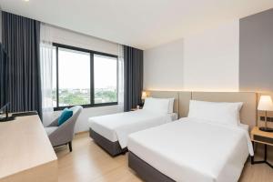 曼谷Best Western Nada Don Mueang Airport hotel的酒店客房设有两张床和窗户。