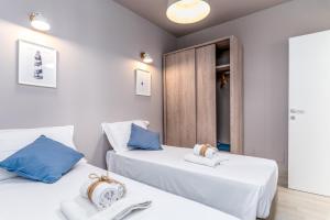 佩斯科勒海滨Mare Villas Pescoluse- Design Apartment的配有白色和蓝色枕头的客房内的两张床