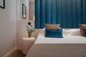 里乔内露恩戈马雷酒店的一间卧室配有一张蓝色窗帘的床