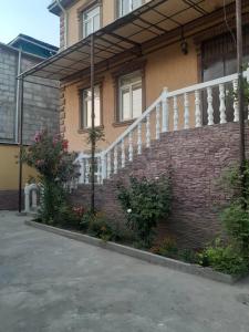 杜尚别3 floor quite cottage in Dushanbe的砖砌的建筑,有白色的栏杆和楼梯