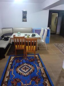杜尚别3 floor quite cottage in Dushanbe的客厅配有桌子、两把椅子和地毯。