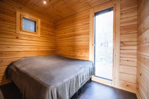 基蒂莱Black Work Levi Aihki的木制客房的一间卧室配有一张床,设有窗户