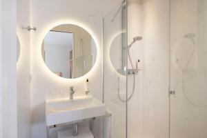 巴黎杜米妮旺多姆酒店的白色的浴室设有水槽和镜子
