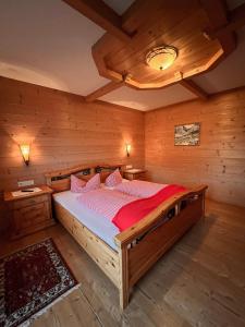 齐勒河谷采尔福斯礅公寓的木制客房内的一间卧室,配有一张床