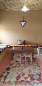 梅尔祖卡Auberge Camping La Khaima的一间配有沙发、桌子和地毯的客房