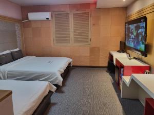 全州市Sharp Hotel Jeonju的酒店客房设有两张床和一台平面电视。