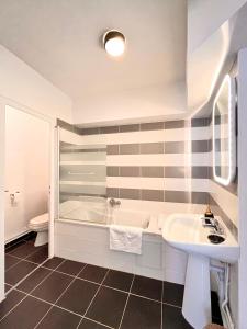 克卢尼商务酒店的白色的浴室设有浴缸和水槽。