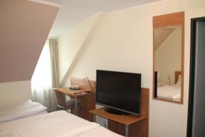 卡门Hotel Stadt Kamen的一间卧室配有一张床和一台平面电视